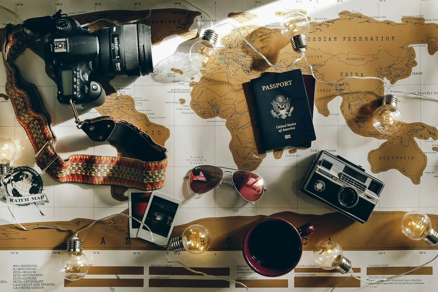 Préparation d’un voyage : passeport, appareil photo et lunettes de soleil sur une carte du monde