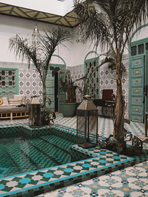Patio de riad à Marrakech avec bassin en zellige et palmiers