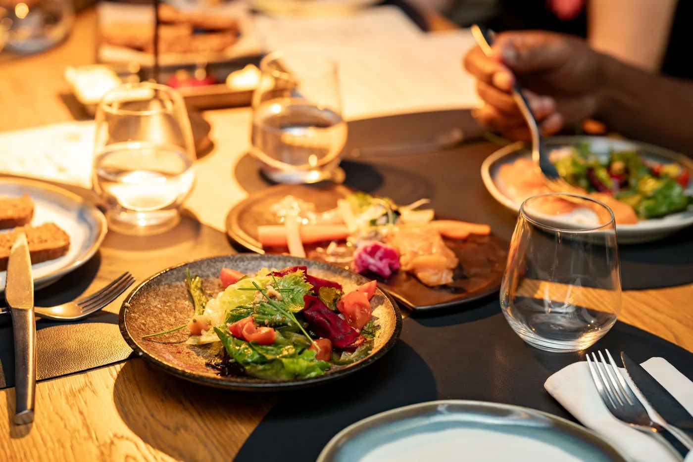 Table de restaurant garnie de salades et de petits plats à partager