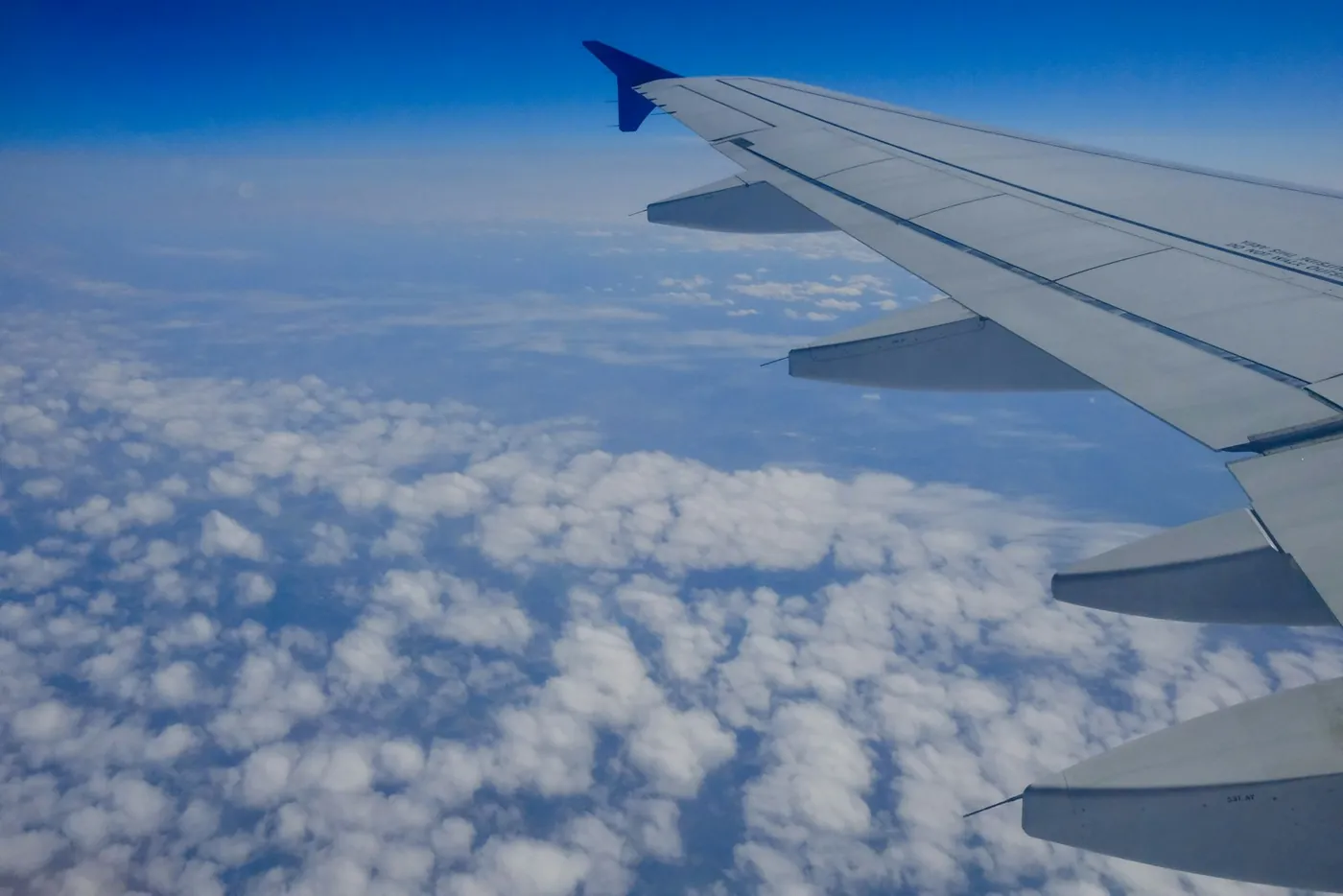Aile d’avion au-dessus des nuages, vue depuis le hublot